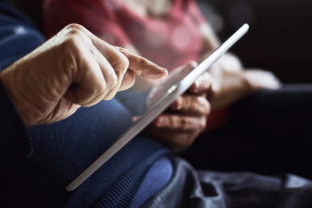 Older person using a tablet with help